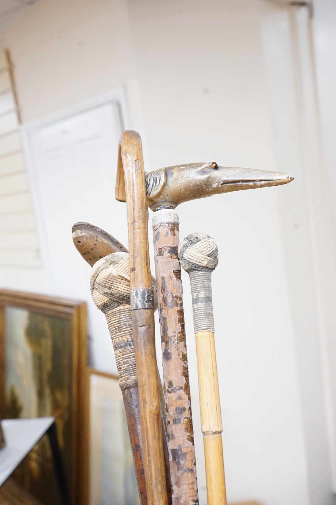 Five walking sticks to include two with rope work handles and one carved in the form of a dog's head, largest 94cm in length